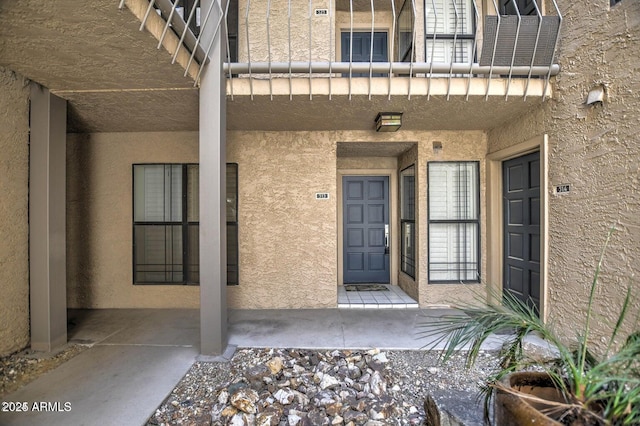 entrance to property featuring stucco siding