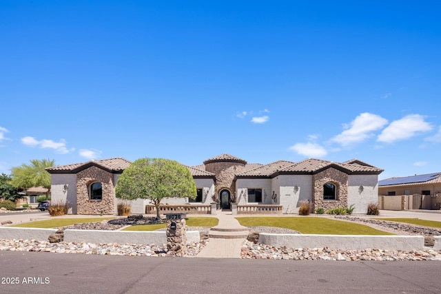 18036 W San Miguel Ave, Litchfield Park, AZ 85340 - mediterranean / spanish-style home with stone siding, a tile roof, stucco siding, and a front lawn