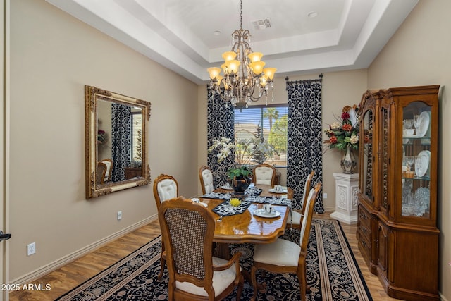18036 W San Miguel Ave, Litchfield Park, AZ 85340 - dining area with a chandelier, light wood-type flooring, a tray ceiling, and baseboards