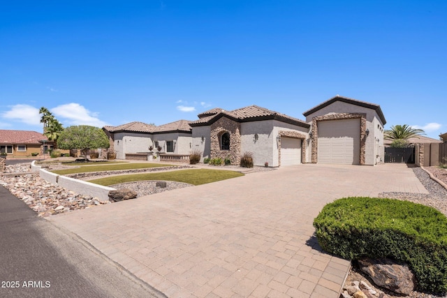 18036 W San Miguel Ave, Litchfield Park, AZ 85340 - mediterranean / spanish house with an attached garage, driveway, stucco siding, a tiled roof, and stone siding