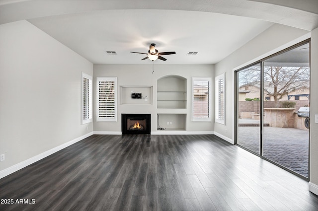 1612 E Zion Way, Chandler, AZ 85249 - unfurnished living room featuring plenty of natural light, ceiling fan, built in features, and dark hardwood / wood-style floors