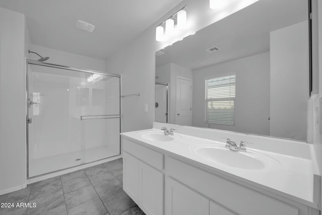 bathroom featuring a shower with door and vanity