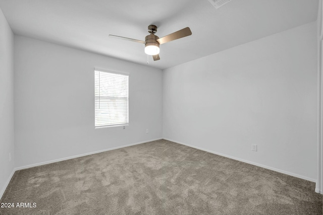 carpeted spare room featuring ceiling fan