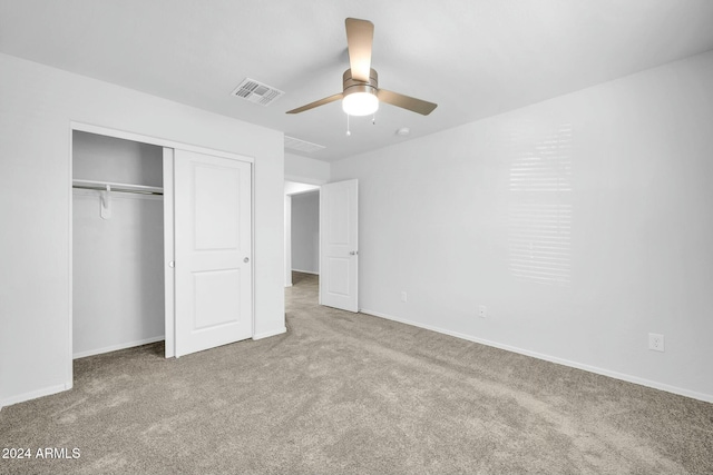 unfurnished bedroom with light carpet, ceiling fan, and a closet