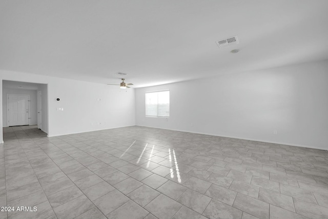 tiled empty room featuring ceiling fan