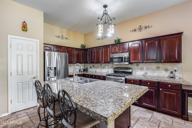 965 E Virgo Pl, Chandler, AZ 85249 - kitchen with appliances with stainless steel finishes, a sink, stone tile flooring, tasteful backsplash, and hanging light fixtures