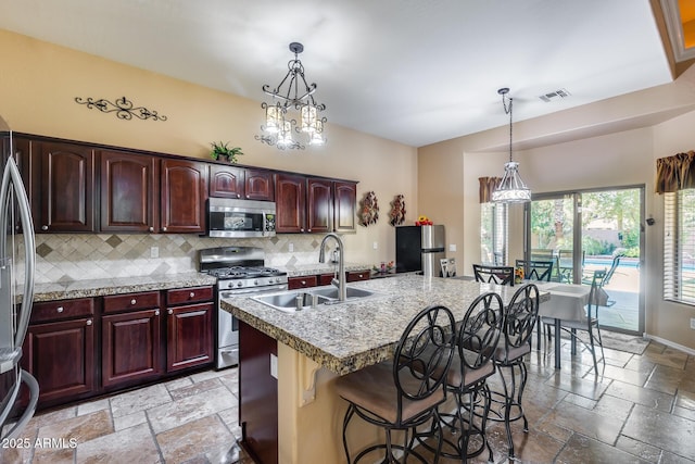 965 E Virgo Pl, Chandler, AZ 85249 - kitchen with stainless steel appliances, stone tile flooring, a sink, backsplash, and light countertops
