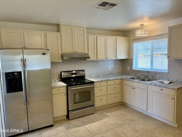 kitchen with hanging light fixtures, sink, light tile patterned flooring, appliances with stainless steel finishes, and tasteful backsplash