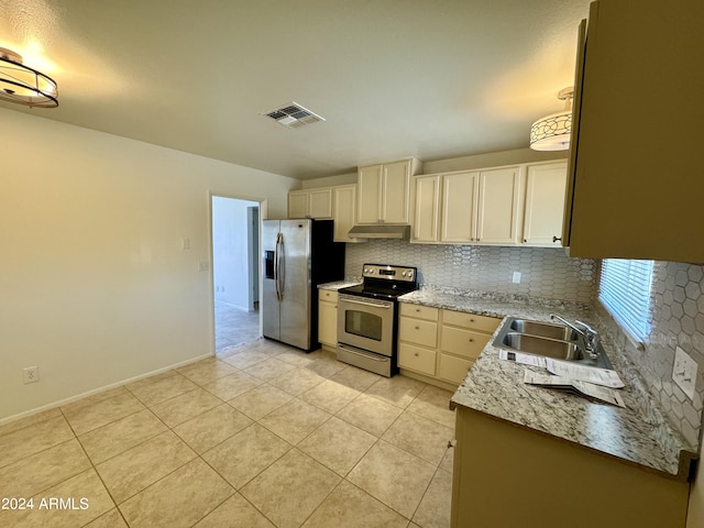 kitchen with sink, appliances with stainless steel finishes, decorative backsplash, and light tile patterned floors