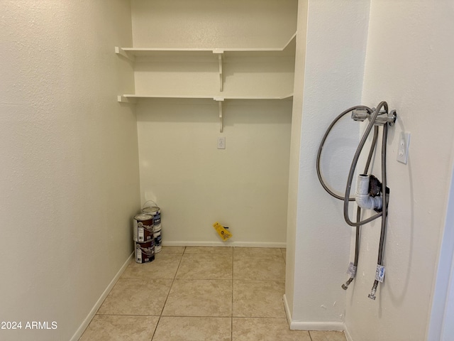 clothes washing area featuring light tile patterned floors