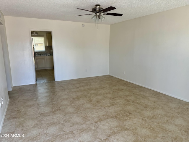 spare room featuring ceiling fan and a textured ceiling