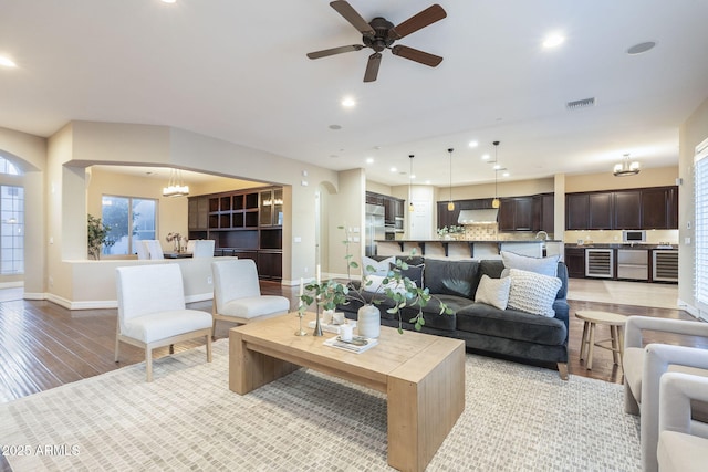 5243 E Windstone Trl, Cave Creek, AZ 85331 - living room with beverage cooler, light wood-type flooring, recessed lighting, ceiling fan, and a chandelier