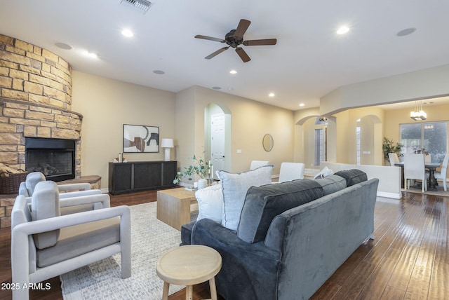 5243 E Windstone Trl, Cave Creek, AZ 85331 - living area with arched walkways, ceiling fan, dark wood-style floors, a stone fireplace, and recessed lighting