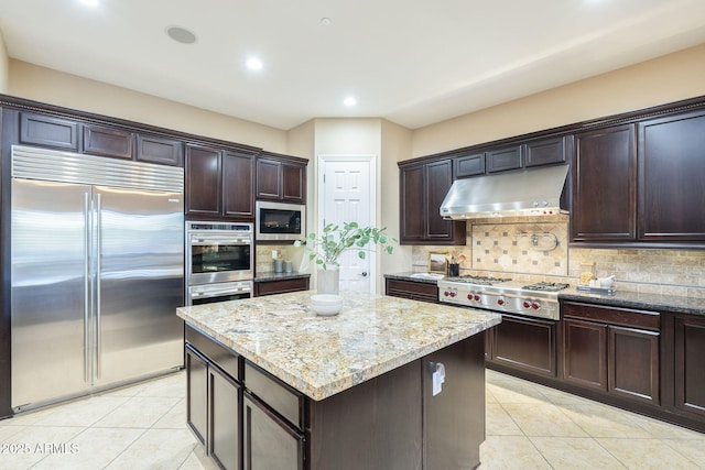5243 E Windstone Trl, Cave Creek, AZ 85331 - kitchen featuring built in appliances, under cabinet range hood, light tile patterned floors, light stone counters, and recessed lighting