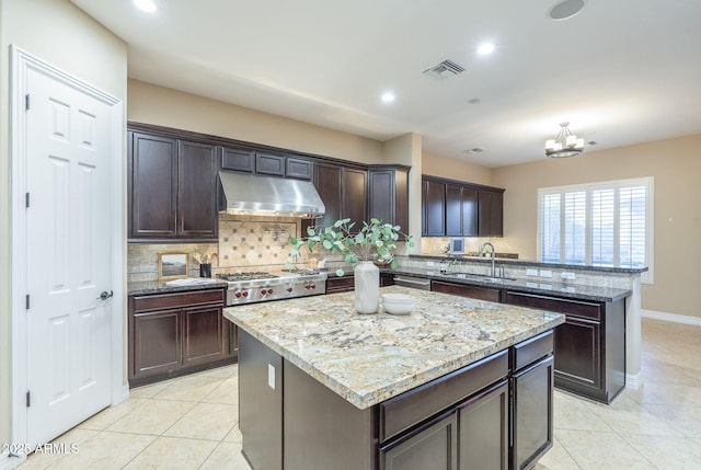 5243 E Windstone Trl, Cave Creek, AZ 85331 - kitchen with under cabinet range hood, a peninsula, light tile patterned flooring, backsplash, and recessed lighting