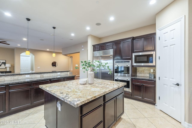 5243 E Windstone Trl, Cave Creek, AZ 85331 - kitchen featuring built in appliances, decorative backsplash, a center island, light tile patterned floors, and recessed lighting