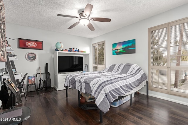 bedroom featuring ceiling fan, dark hardwood / wood-style floors, and a textured ceiling