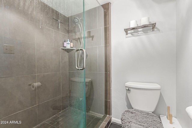 bathroom with a shower with door and toilet