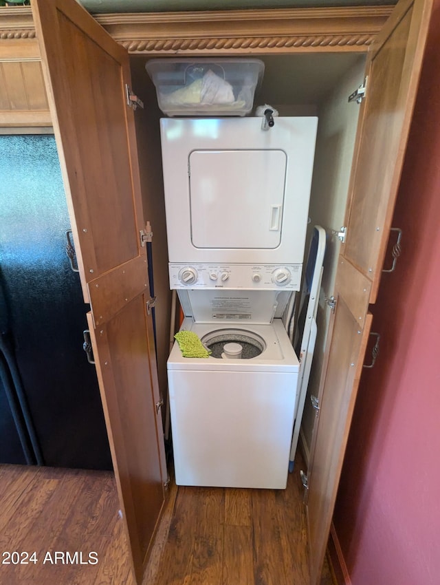 laundry room with stacked washer / drying machine and dark hardwood / wood-style floors