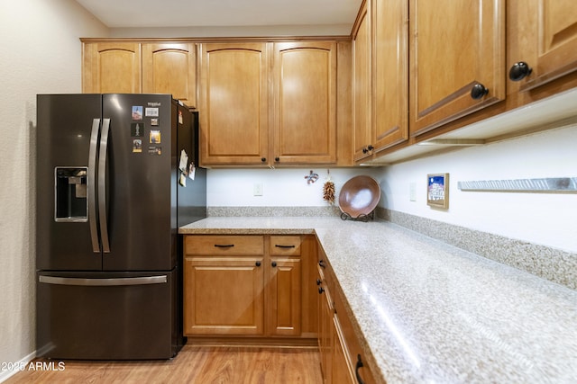 kitchen featuring stainless steel fridge with ice dispenser and light wood-type flooring