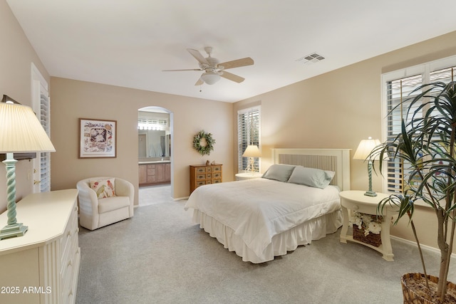 bedroom featuring ensuite bath, ceiling fan, and light carpet