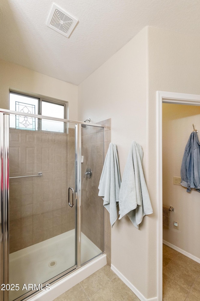 bathroom featuring tile patterned flooring and a shower with door