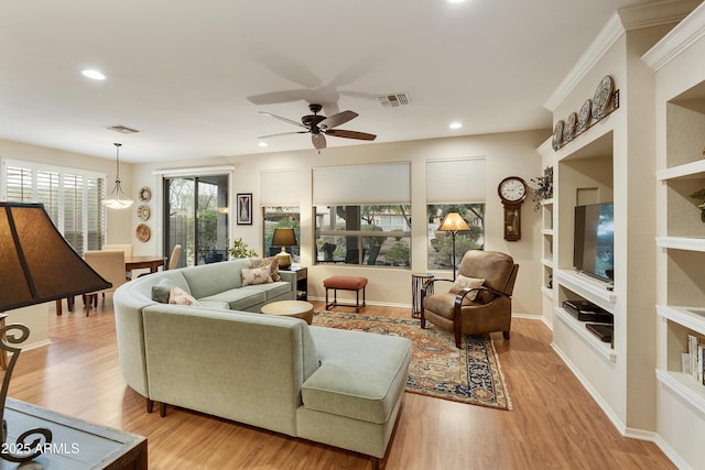 living room featuring light hardwood / wood-style flooring, built in features, and ceiling fan