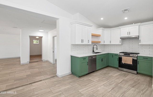 19401 W Flower St, Litchfield Park, AZ 85340 - kitchen with green cabinetry, stainless steel appliances, white cabinets, under cabinet range hood, and tasteful backsplash