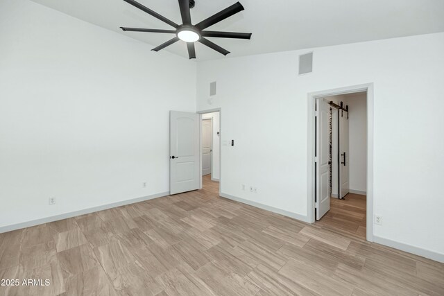 19401 W Flower St, Litchfield Park, AZ 85340 - unfurnished bedroom featuring baseboards, light wood-style floors, and high vaulted ceiling