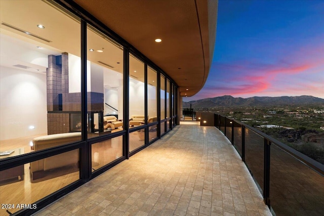 balcony at dusk featuring a mountain view