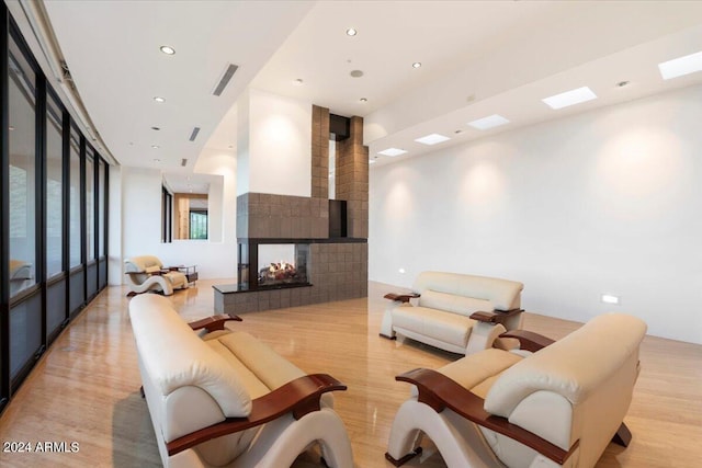 living room with a multi sided fireplace and light hardwood / wood-style floors