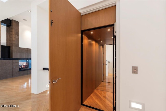 hallway with light wood-type flooring and elevator