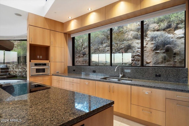 kitchen featuring dark stone counters, plenty of natural light, sink, and black electric stovetop