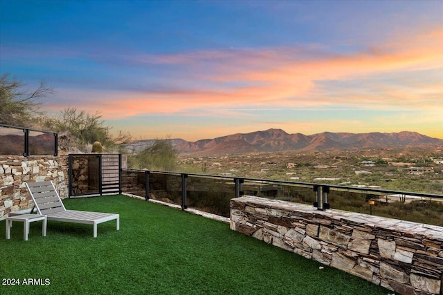 yard at dusk featuring a mountain view