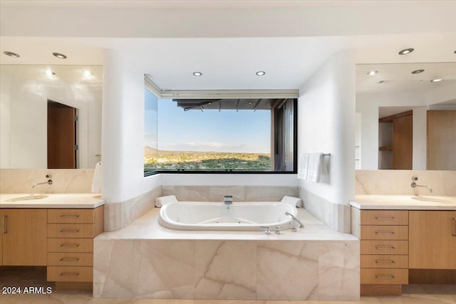 bathroom with vanity, tiled bath, and tile patterned flooring