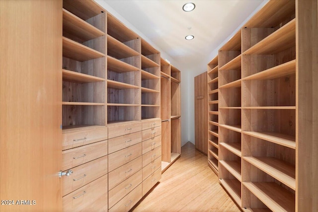 walk in closet with light hardwood / wood-style flooring