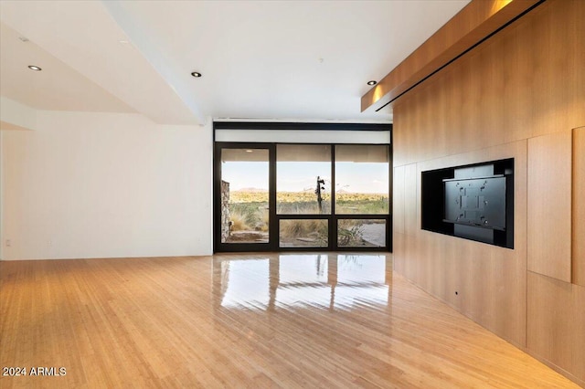 unfurnished living room with floor to ceiling windows and light wood-type flooring