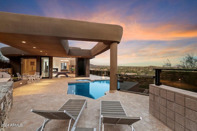 pool at dusk featuring a patio