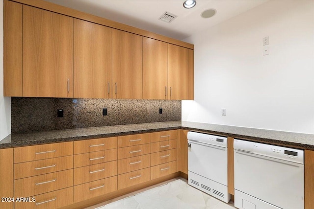 kitchen with decorative backsplash, dark stone counters, and white dishwasher