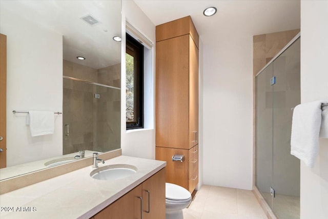 bathroom with vanity, a shower with shower door, toilet, and tile patterned floors