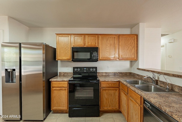 kitchen with sink, light tile patterned flooring, and black appliances