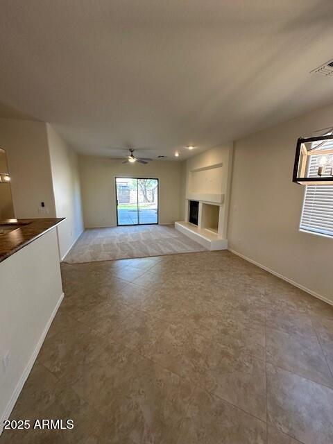 unfurnished living room featuring ceiling fan