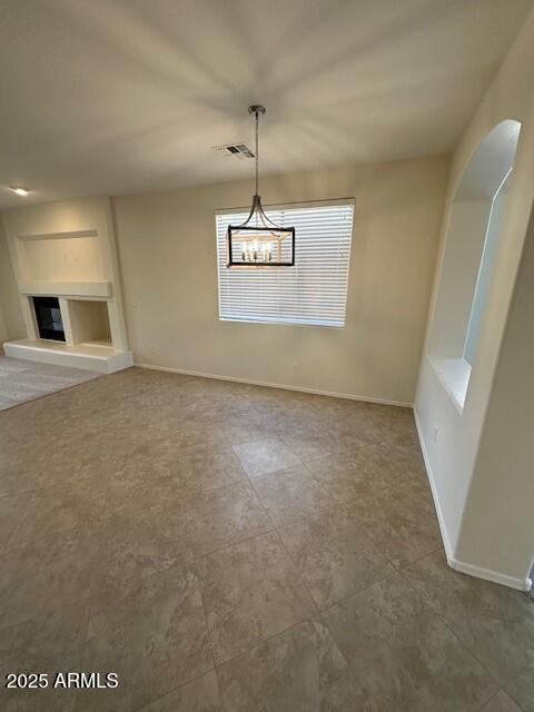 unfurnished dining area with an inviting chandelier and built in features