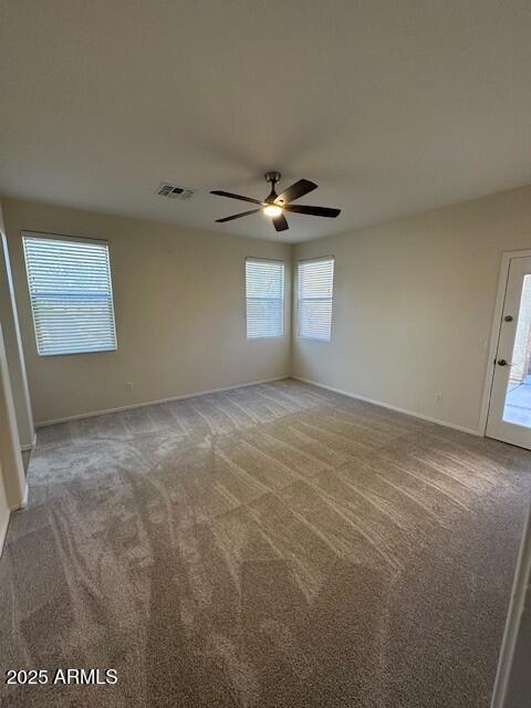 carpeted spare room with ceiling fan