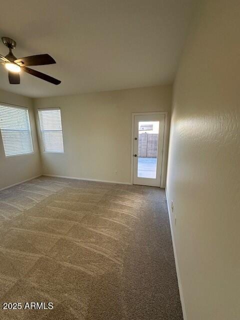 carpeted spare room with ceiling fan