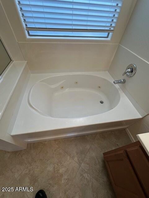 bathroom featuring a washtub, tile patterned floors, and vanity