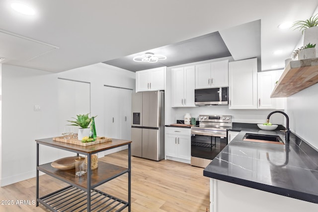 kitchen featuring stainless steel appliances, white cabinetry, and sink