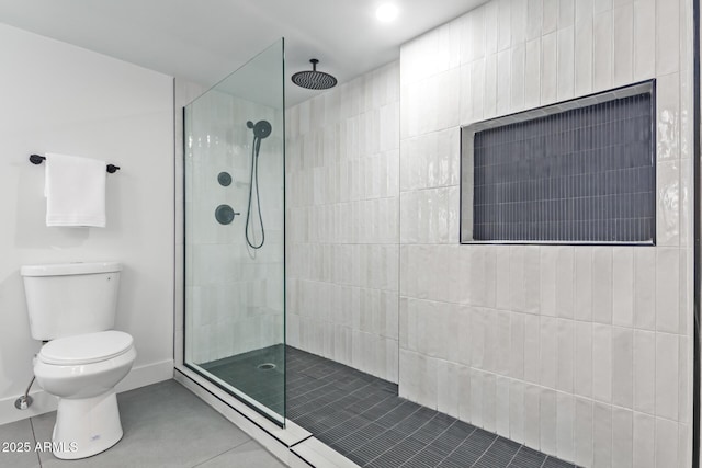 bathroom with toilet, tile patterned flooring, and a tile shower