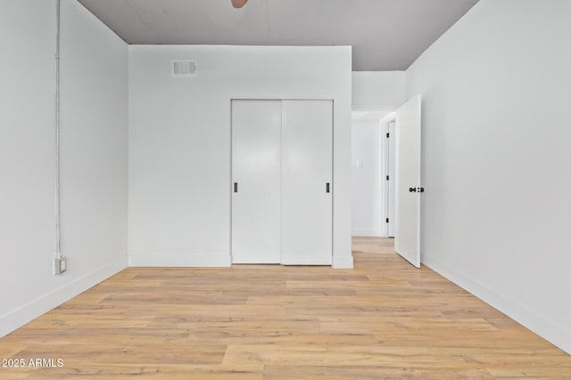 unfurnished bedroom with a closet and light hardwood / wood-style floors