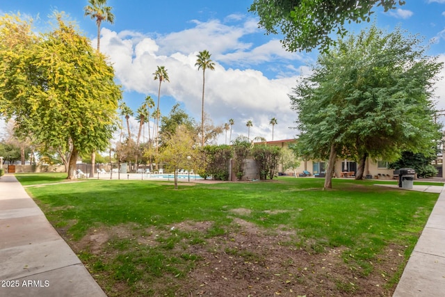 view of property's community featuring a lawn and a pool